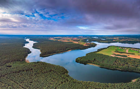 Aerial view of Ancia lake in Lithuania, shiny reflection of sky with clouds in the water of the lakeの写真素材