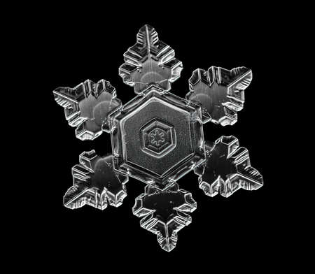 White snowflake isolated on black background. Illustration based on macro photo of real snow crystal: elegant star plate with short, broad arms, glossy relief surface and complex inner details.の写真素材