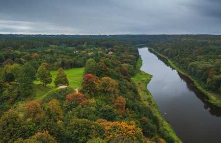 Punia mound in Lithuania with green grass and autumn trees background, road to mountainの写真素材