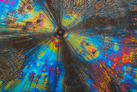 Extreme macro photograph of Vitamin C crystals forming abstract modern art patterns, when illuminated with polarized light, under a microscope objective with 10x magnificationの写真素材
