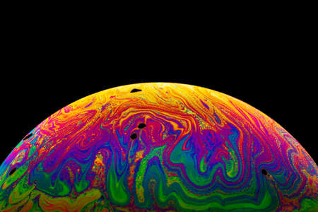 Virtual reality space with abstract multicolor psychedelic planet. Closeup Soap bubble like an alien planet on black background.の写真素材