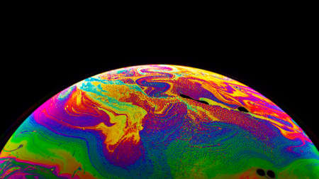Virtual reality space with abstract multicolor psychedelic planet. Closeup Soap bubble like an alien planet on black background.の写真素材