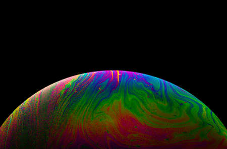 Virtual reality space with abstract multicolor psychedelic planet. Closeup Soap bubble like an alien planet on black background.の写真素材