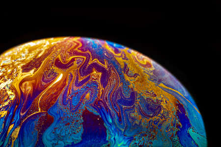 Virtual reality space with abstract multicolor psychedelic planet. Closeup Soap bubble like an alien planet on black background.の写真素材