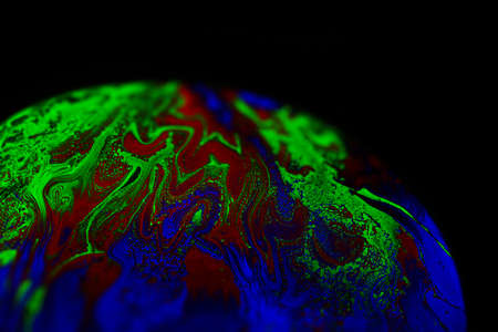 Virtual reality space with abstract multicolor psychedelic planet. Closeup Soap bubble like an alien planet on black background.の写真素材