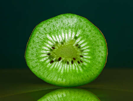 Slice of kiwi fruit close-up on dark background. Horizontal. space for textの写真素材