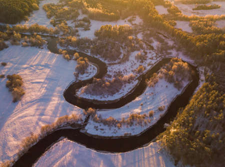 Aerial view from the top down winter day river bend with snowy frozen shoreの写真素材