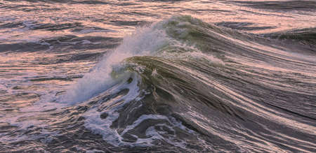 Wave breaking in the Baltic sea, evening light, background image of sea waveの写真素材