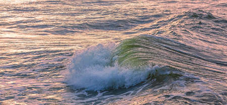 Wave breaking in the Baltic sea, evening light, background image of sea waveの写真素材