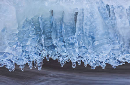 Icicles over the water in the river. Natural landscape. Winter. Background image.の写真素材