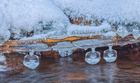 Icicles over the water in the river. Natural landscape. Winter. Background image.の写真素材