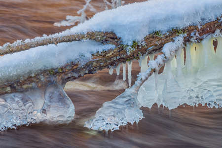 Icicles over the water in the river. Natural landscape. Winter. Background image.の写真素材