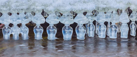 Icicles over the water in the river. Natural landscape. Winter. Background image.の写真素材