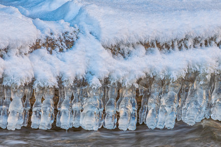 Icicles over the water in the river. Natural landscape. Winter. Background image.の写真素材