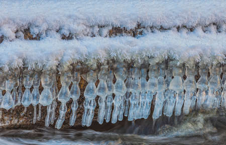 Icicles over the water in the river. Natural landscape. Winter. Background image.の写真素材