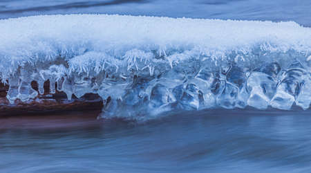 Icicles at winter, cold weather with icicles over river streamの写真素材