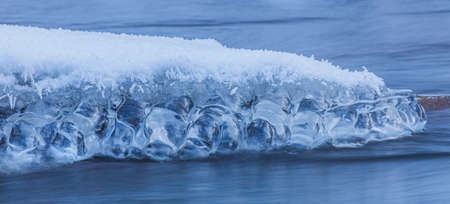 Icicles at winter, cold weather with icicles over river streamの写真素材