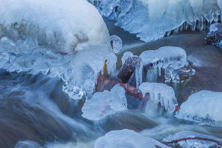 Icicles at winter, cold weather with icicles over river streamの写真素材