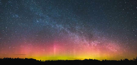 Milky way and Northern lights - Aurora borealis over the forestの写真素材