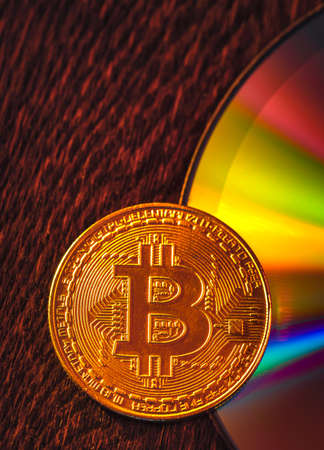 Bitcoin coin on a CD - DVD, background for designの写真素材