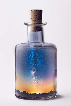 Isolated bottle filled with night sky and milky way stars, surrealism bottleの写真素材