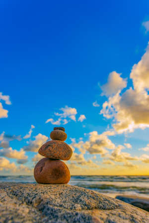 Stone tower on the beach with evening sunset lightの写真素材