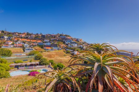 Madeira landscape, settlements built on high cliffs or in the hillsides rising steeply right from the sea shores, Garajau, Madeira island, Portugalの写真素材