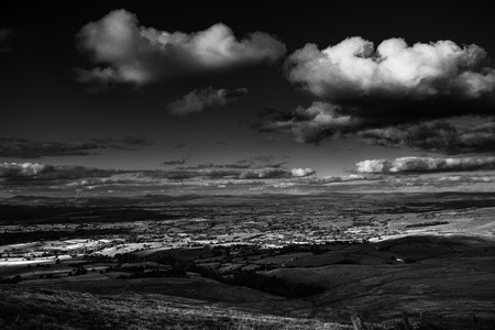 Scenic view from Pendle Hill, North- East, Clouds cast shadows over Lancashire Hills. In distance Yorkshire highest peaks:Pen-y-Ghent, Ingleborough, Whernside. Black and white. Forest Of Bowland. West Pennine Moors. Lancashire. England, UKの写真素材