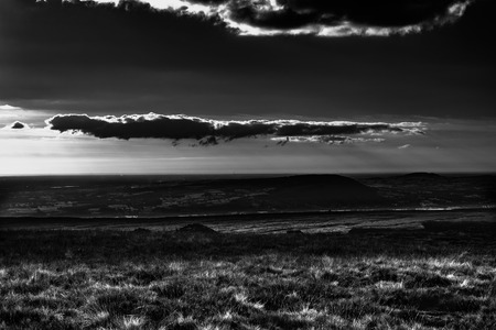 Scenic view from Pendle Hill,West. Clouds cast shadows over Lancashire Hills. In distance Blackpool and Irish sea. Black and white. Forest Of Bowland. West Pennine Moors. Lancashire. England, UKの写真素材