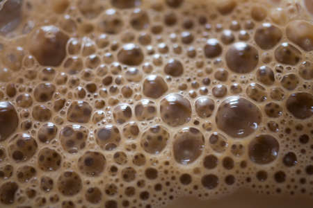 Interesting background of beige coffee foam in closeup