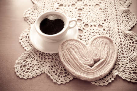 a small white cup of black coffee and a sweet buttery cookie on the tableの写真素材