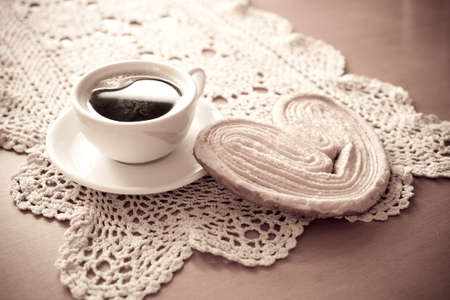 a small white cup of black coffee and a sweet buttery cookie on the tableの写真素材