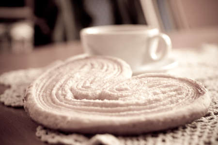 a small white cup of black coffee and a sweet buttery cookie on the tableの写真素材