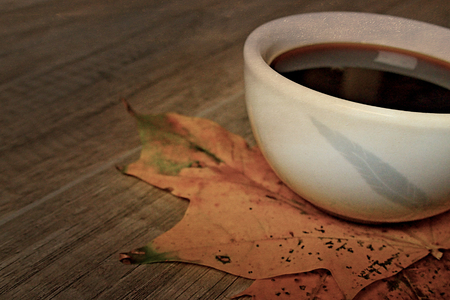 very hot autumn black espresso coffee on a wooden table and autumn maple leavesの写真素材