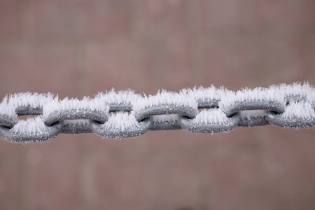 a metal chain covered with white frost on a pastel backgroundの写真素材