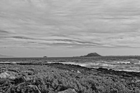 beautiful sea landscape with the ocean and a view of the Spanish island of De Lobos with a ship in...