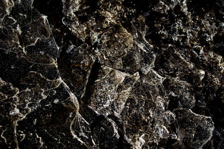 beautiful interesting abstract background with ice close-up on a frozen puddle