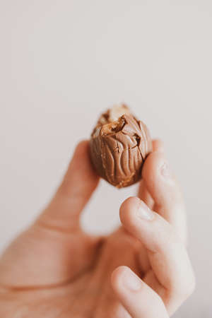 beautiful little bitten chocolate easter egg in a child's handの写真素材