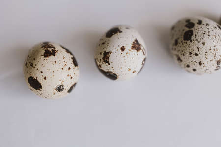 beautiful little quail eggs on a light smooth background in close-up