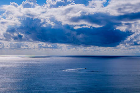 beautiful calm blue seaside landscape with water and sky and sailboats