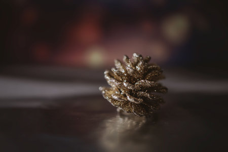 beautiful golden christmas cone on the background of bokeh in closeupの写真素材