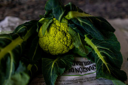 beautiful green organic green cauliflower on a kitchen countertop in closeup