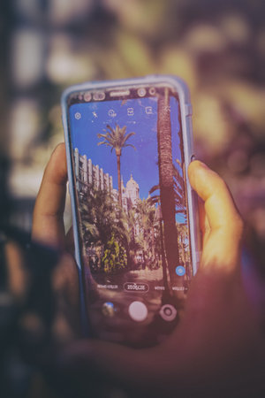 mobile phone in hands while taking beautiful photo explanada in Alicante, Spainの写真素材