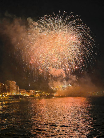 beautiful colorful fireworks in the night sky on the seafront of Alicante spainの写真素材