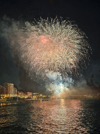 beautiful colorful fireworks in the night sky on the seafront of Alicante spainの写真素材