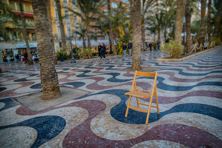 beautiful Explanada promenade in Alicante Spain landmark with wooden empty chair on mosaicの写真素材