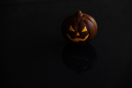 beautiful chocolate halloween pumpkin jack-o-lantern on dark backgroundの写真素材