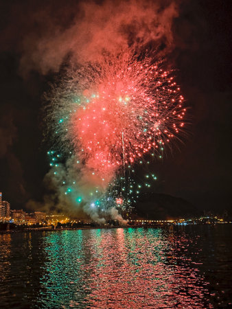 beautiful colorful fireworks in the night sky on the seafront of Alicante spainの写真素材