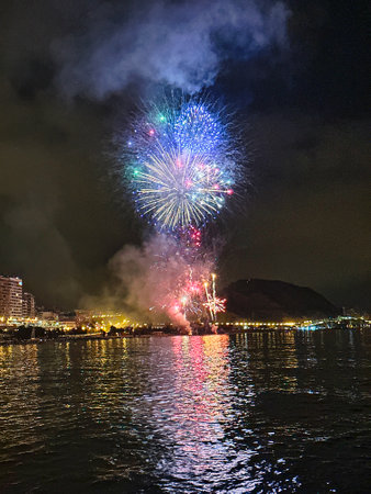 beautiful colorful fireworks in the night sky on the seafront of Alicante spainの写真素材