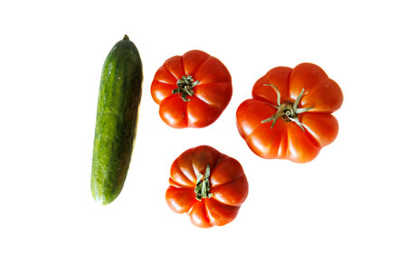 beautiful tomato and green cucumber on a white backgroundの写真素材